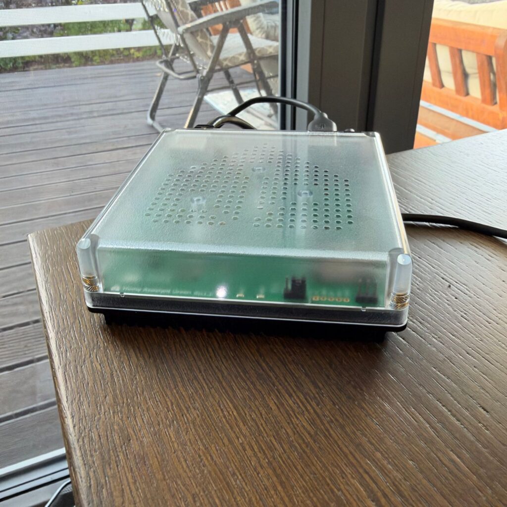 Centralka Home Assistant Green na drewnianym stole przy oknie tarasowym